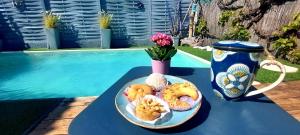 a blue table with a plate of donuts and a cup at Villa Clea in Saint-Paul-lez-Durance