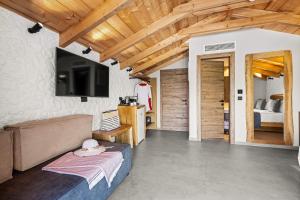 a living room with a couch and a tv at Emily's Luxury Suites in Pefkochori
