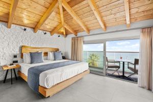 a bedroom with a bed and a view of the ocean at Emily's Luxury Suites in Pefkochori