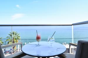 two glasses on a table with a view of the ocean at Emily's Luxury Suites in Pefkochori