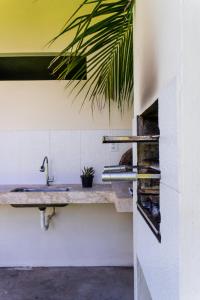 a bathroom with a sink on a wall at Bahia Soul - Bangalô Lua - Grupo Barril Hospedagens in Marau