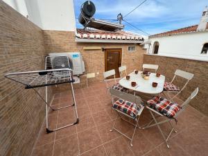 a patio with a grill and a table and chairs at Casa Arenga in Almádena