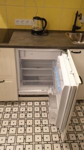 an open refrigerator with its door open in a kitchen at kauno street home in Vilnius