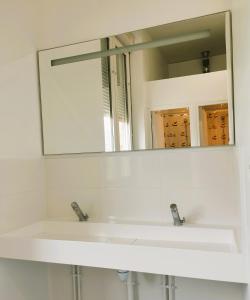 bagno con lavandino bianco e specchio di L'Etape du Mont, Family Hostel a Pontorson
