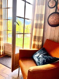 ein Wohnzimmer mit einem Sofa und einem Fenster in der Unterkunft Le Crêt, petit nid au pied des cimes in Nendaz