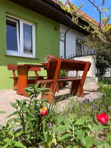 a wooden picnic table and bench in front of a house at Domek Zielony in Unieście