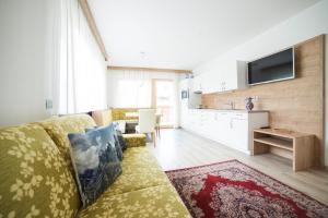 a living room with a couch and a kitchen at Residence Ravisa in Selva di Val Gardena