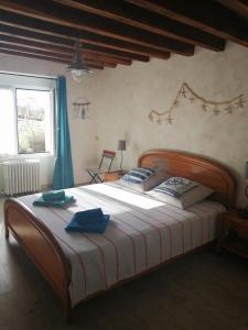um quarto com uma cama grande e toalhas azuis em Vendrennes Chez Florymarysol em Vendrennes