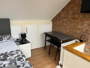 a bedroom with a bed and a desk with a table at North West Lodge Guest House in London