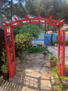una puerta roja en un patio con un cobertizo en Appartement jardin Cap d'Agde en Cap d'Agde