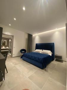 a bedroom with a blue bed and a desk at IL DUCA HOUSE e HOLIDAY PRESTIGE in Caccamo