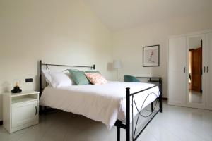 1 dormitorio con 1 cama con sábanas y almohadas blancas en Villa Profumo di Salvia, en Magione
