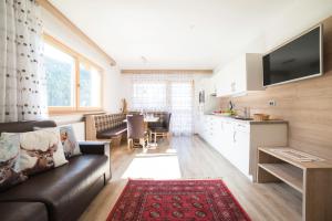 a living room with a couch and a dining room at Residence Ravisa Dolomites in Selva di Val Gardena