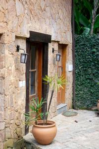 una gran olla sentada frente a un edificio de piedra en Pousada Águas da Serra en Petrópolis