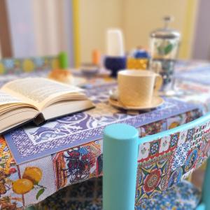 een open boek zittend op een tafel met een tafelkleed bij BED&BOOK Palazzo Cutelli in Palermo