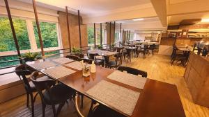 a restaurant with tables and chairs and large windows at Verde Vale Hotel in Videira