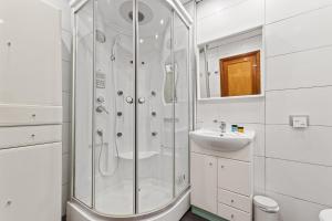 La salle de bains blanche est pourvue d'une douche et d'un lavabo. dans l'établissement Apartamento Leon 2, à Arrecife