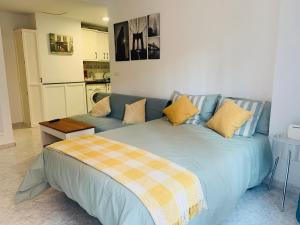 a bedroom with a bed and a couch in it at ACUARIO 22 in Benalmádena