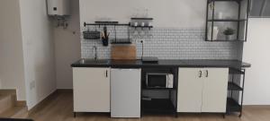 a kitchen with white cabinets and a black counter top at A Lobeira in Corcubión