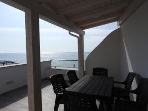 einen Tisch und Stühle auf einem Balkon mit Meerblick in der Unterkunft Appartamenti Lungomare Circeo in San Felice Circeo