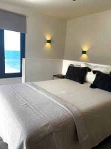 a bedroom with a large white bed with a window at Casa Lúa in Santa Maria de Guia de Gran Canaria