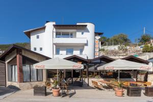 two white umbrellas in front of a building at Мотел "Релакс" Motel "Relax", Балчик, in Balchik