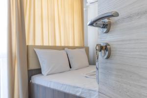 a bed in a room next to a door at Мотел "Релакс" Motel "Relax", Балчик, in Balchik