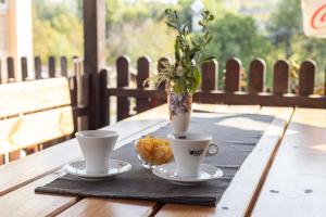 two coffee cups and a vase on a wooden table at Мотел "Релакс" Motel "Relax", Балчик, in Balchik +13 photos