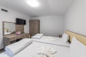 a hotel room with two beds and a mirror at Мотел "Релакс" Motel "Relax", Балчик, in Balchik
