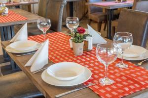 a wooden table with plates and wine glasses on it at Мотел "Релакс" Motel "Relax", Балчик, in Balchik