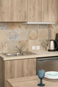 a kitchen with a sink and a stove at SAND rooms to let in Nea Roda