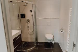uma casa de banho com um chuveiro, um WC e um lavatório. em B&B Oan't Wetter em Dokkum
