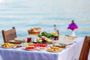 a table with food on it with the ocean in the background at Baldan Suites in Bozburun