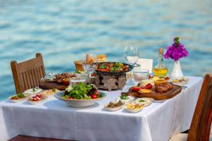 a table with food and drinks on a table by the water at Baldan Suites in Bozburun