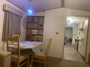 eine Küche und ein Esszimmer mit einem Tisch und Stühlen in der Unterkunft The Pearl - Deluxe Access Caravan in Skegness