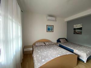 a bedroom with two beds and a window at Apartments Vido in Kotor