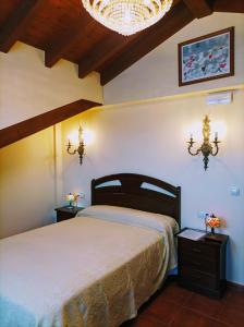 a bedroom with a large bed and a chandelier at Casa Pelayin in Cue