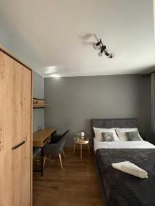a bedroom with a bed and a table and a desk at Cozy Studio 1 Bedroom nearby Value Center Mall in Zalău
