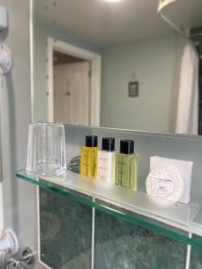 - une étagère dans une salle de bains pourvue d'un miroir dans l'établissement The Limes By Luigis Al Fresco, à Maldon