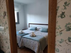 een slaapkamer met 2 bedden en handdoeken bij The Way Apartamento in O Pedrouzo