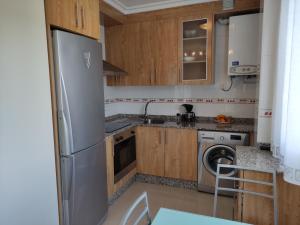 uma cozinha com um frigorífico e uma máquina de lavar louça em The Way Apartamento em O Pedrouzo