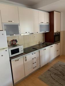 a kitchen with white cabinets and white appliances at Apartment IDA in Budva +8 photos