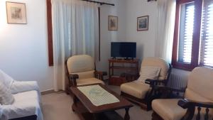 a living room with chairs and a tv and a table at Chalet Cala Figuera in Cala Figuera