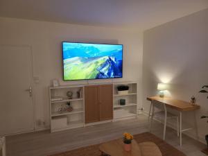 a living room with a flat screen tv on a wall at Appartement zen et calme, centre ville in Vendôme