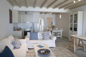a living room with two white couches and a kitchen at Beachfront 2br apartment - Free parking in Serifos Chora