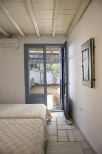 a bedroom with a bed and an open door at Beachfront 2br apartment - Free parking in Serifos Chora