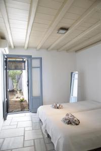 dwa łóżka w pokoju z otwartymi drzwiami w obiekcie Beachfront 2br apartment - Free parking w mieście Serifos Chora