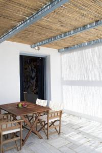 a wooden table and chairs on a patio at Beachfront 2br apartment - Free parking in Serifos Chora