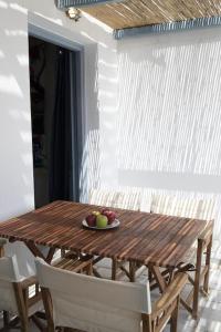a wooden table with a plate of fruit on it at Beachfront 2br apartment - Free parking in Serifos Chora