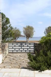 a bench sitting on a stone path near the beach at Beachfront 2br apartment - Free parking in Serifos Chora